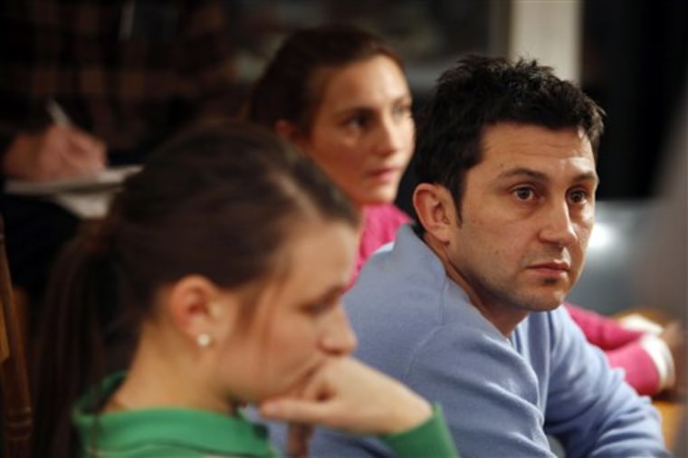 In this Jan. 19 photo, Emilio Maya, right, is surrounded by his wife, Kseniya Maya, left, and his sister, Analia Maya, during a strategy meeting with supporters in Saugerties, N.Y. The brother and sister say federal immigration officials reneged on a promise of a special visa allowing them to stay in the U.S. in return for their undercover work.